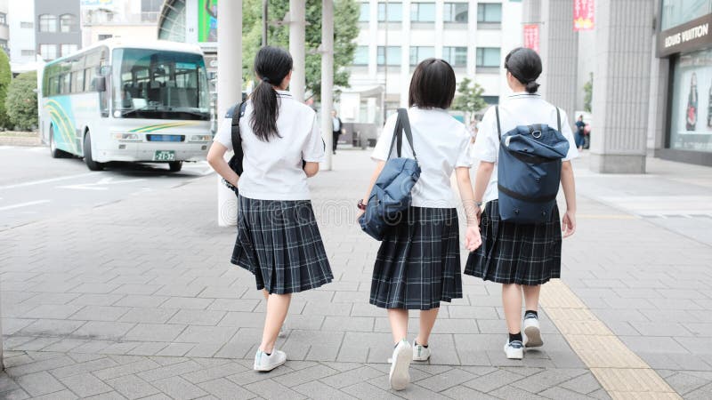 Selective shot of three schoolgirls wearing uniform and backpacks walking to the school-bus royalty free stock images Selective shot of three schoolgirls wearing uniform and backpacks walking to the school-bus royalty free stock images