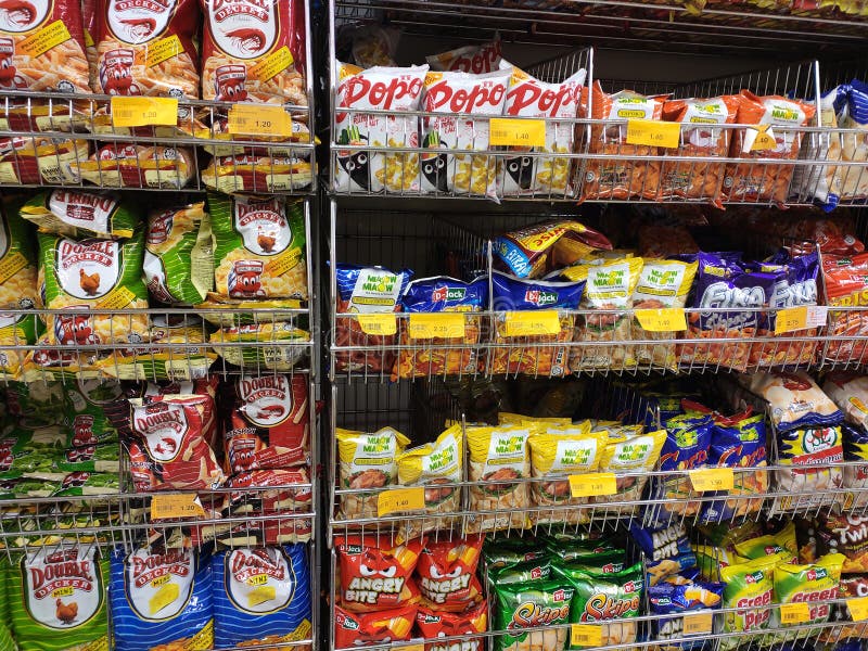 Selectivo focalizado de varios alimentos basura y aperitivos empaquetados en el rack y exhibiciÃ³n para la venta en el supermercad