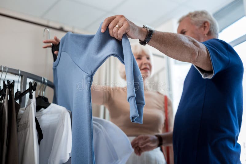 Selektiv fokus av den trendiga sweatern i händer av kunder arkivfoto Selektiv fokus av den trendiga sweatern i händer av kunder arkivfoto
