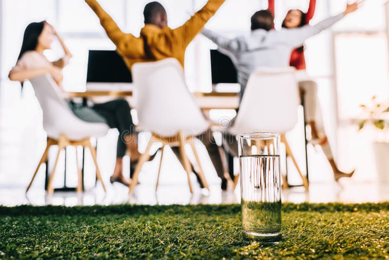 selektiv fokus av exponeringsglas av vatten och multietniskt affärsfolk som sitter på tabellen arkivbilder selektiv fokus av exponeringsglas av vatten och multietniskt affärsfolk som sitter på tabellen arkivbilder
