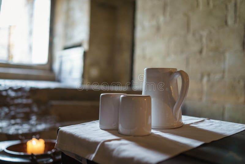Selektiv fokus på den vita keramiska tekrukan och tekoppar med ljus royaltyfria foton Selektiv fokus på den vita keramiska tekrukan och tekoppar med ljus royaltyfria foton