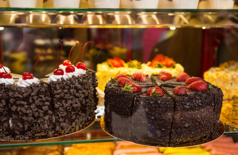 Selection of Decadent Fruit Topped Chocolate Cakes in Bakery Window Display. Selection of Decadent Fruit Topped Chocolate Cakes in Bakery Window Display