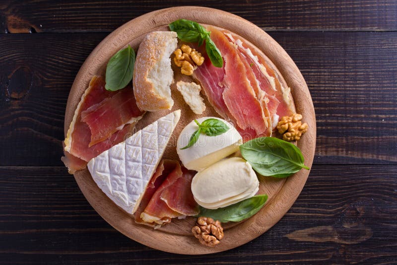 Selezione del formaggio su fondo rustico di legno Vassoio del formaggio con i formaggi, il jamon o il prosciutto di Parma differe fotografie stock