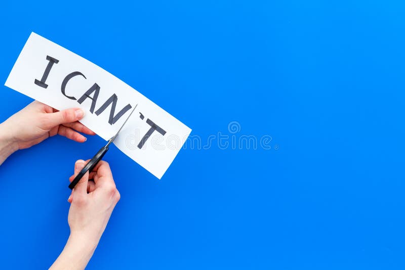 Self confidence concept. Cutting the letter t of written word I can`t by sciccors. Blue background top view copy space