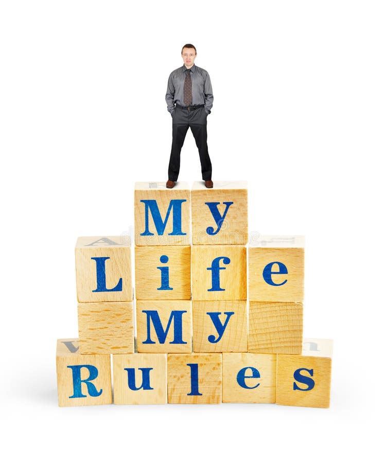 Self confident man stands on the top of wooden cubes with text My Life My Rules stock images Self confident man stands on the top of wooden cubes with text My Life My Rules stock images