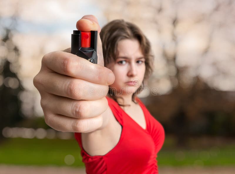 Self-defense concept. Young woman holds pepper spray in hand
