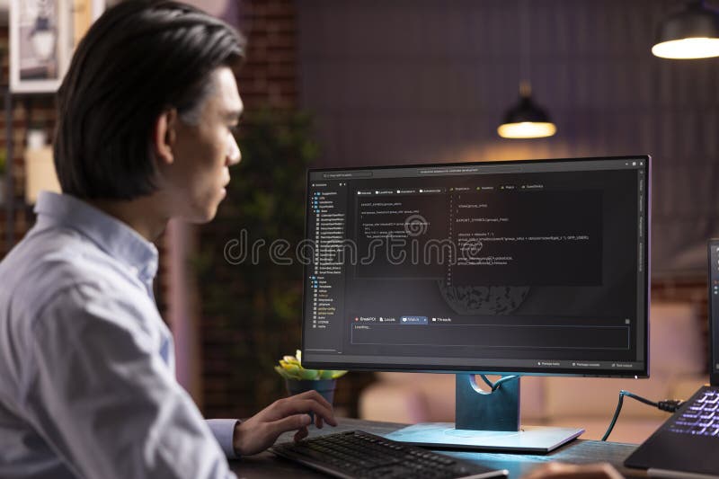 Self employed asian programmer working late at desk stock images