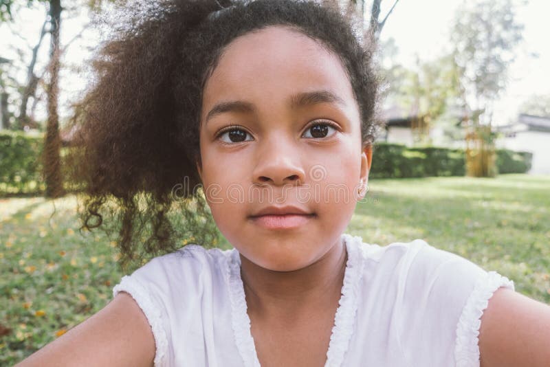 Selfie afro-americano da menina da raça misturada da criança exterior foto de stock Selfie afro-americano da menina da raça misturada da criança exterior foto de stock