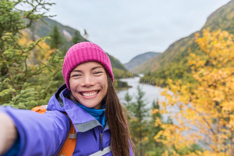 Selfie Aziatisch meisje die in de bergen van de de herfstaard wandelen Gelukkige wandelaarvrouw die de holdingstelefoon nemen van royalty-vrije stock afbeelding Selfie Aziatisch meisje die in de bergen van de de herfstaard wandelen Gelukkige wandelaarvrouw die de holdingstelefoon nemen van royalty-vrije stock afbeelding