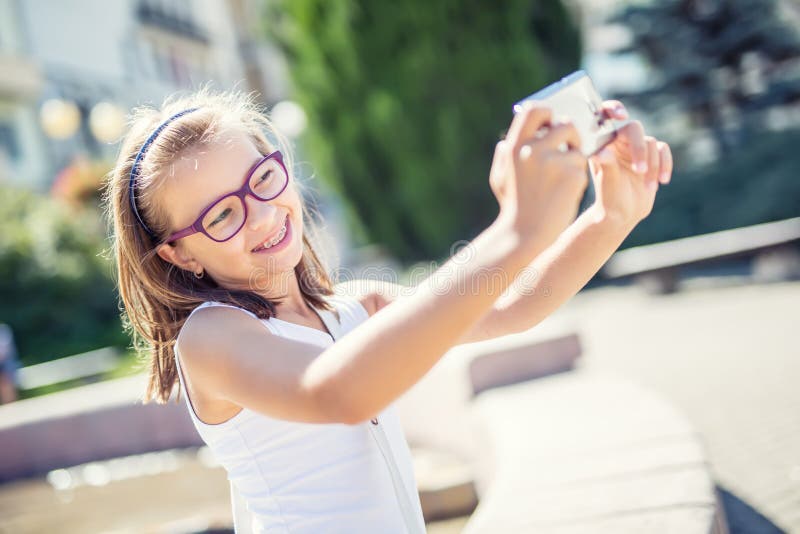 Selfie Belle jeune fille mignonne avec des accolades et des verres riant pour un selfie photo stock Selfie Belle jeune fille mignonne avec des accolades et des verres riant pour un selfie photo stock