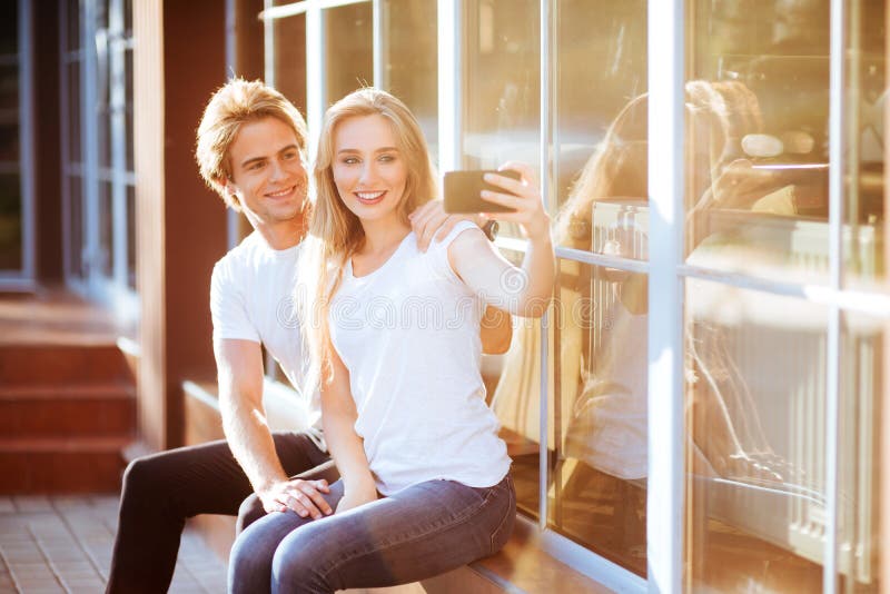 Selfie con Smartphone, par joven feliz imagenes de archivo Selfie con Smartphone, par joven feliz imagenes de archivo