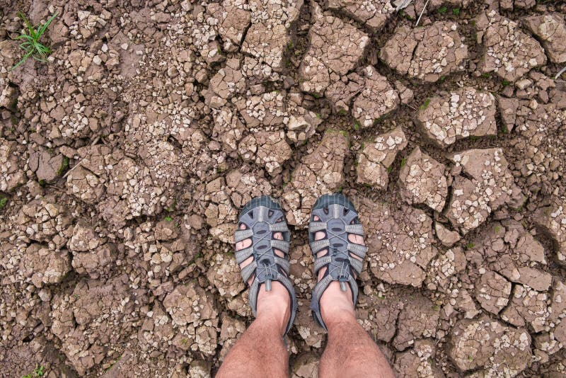 Selfie of feet Traveler men with hiking sandals standing on On the ground that separates the cracked. royalty free stock image Selfie of feet Traveler men with hiking sandals standing on On the ground that separates the cracked. royalty free stock image