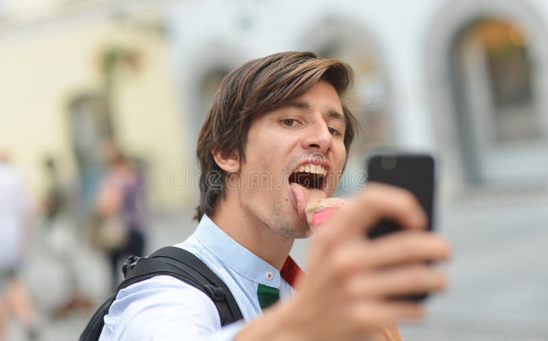 Selfie of handsome young man eating ice cream stock images