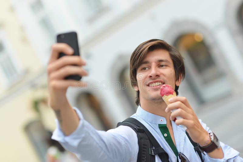 Selfie of handsome young man eating ice cream royalty free stock photos