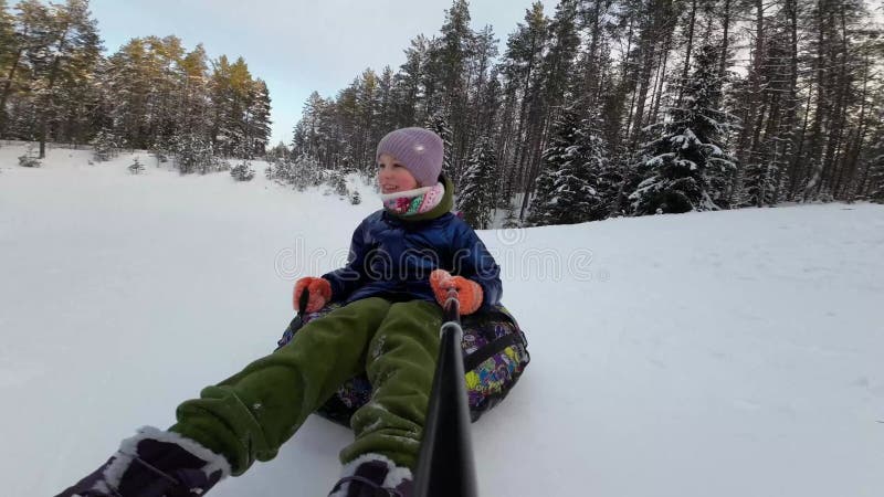 Selfie of Happy Child guida una slitta su un pendio di neve. stock footage