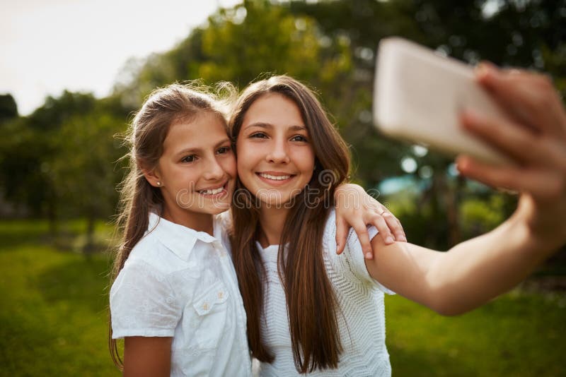 Selfie Sisters. Two Young Sisters Taking Selfies in the Park. Stock ...