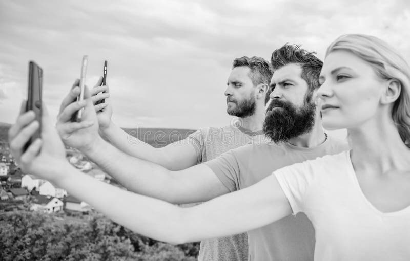 Selfie trouxe pela autoconfian? a Mulher bonita e homens que guardam smartphones nas m? os Melhores amigos que tomam o selfie com imagens de stock royalty free