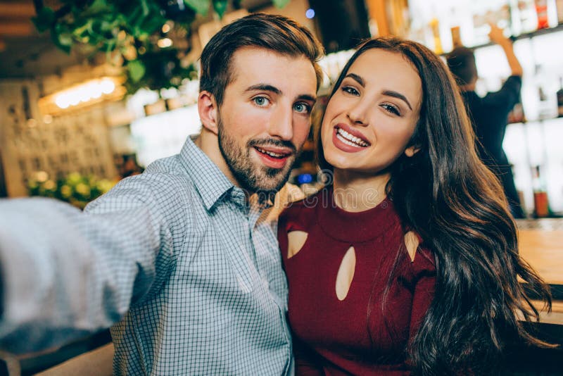 Selfie of Two Beautiful People Sitting Together in a Bar. he is Taking