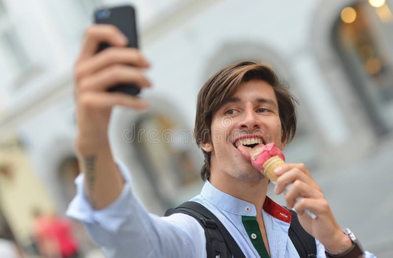 Selfie van de knappe jonge mens die roomijs eten royalty-vrije stock afbeeldingen Selfie van de knappe jonge mens die roomijs eten royalty-vrije stock afbeeldingen