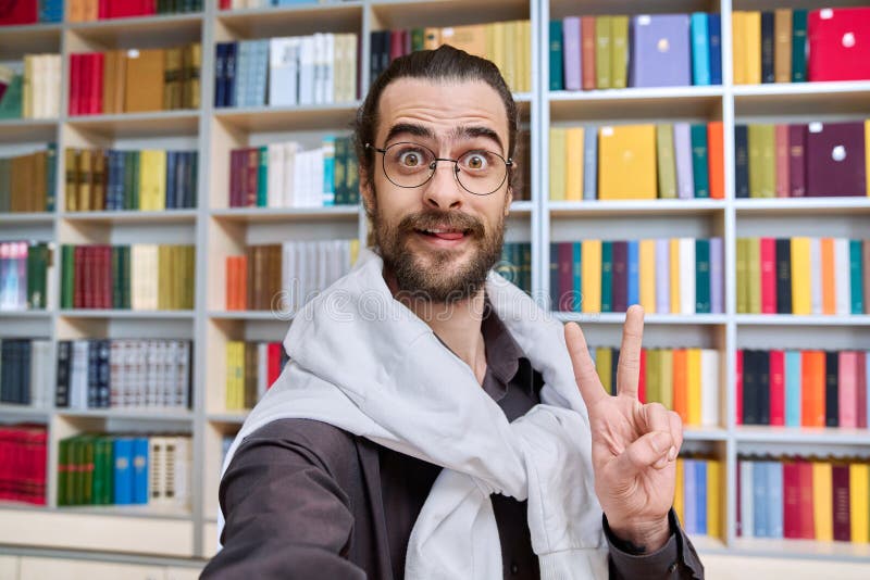 Selfie zdjęcie portret młody 30 lat pozytywny człowiek w okularach wewnątrz biblioteki obrazy royalty free