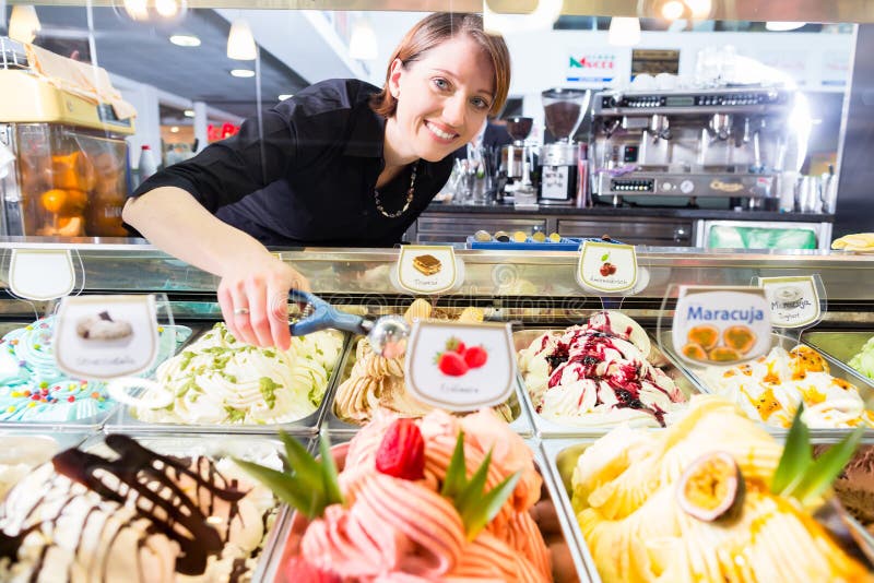 Seller presenting ice cream in parlor display