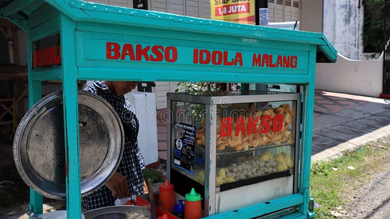 Meatball street food vendor. Asian man selling bakso by walking and pushing down the food carts, Pekalongan, December 27, 2021