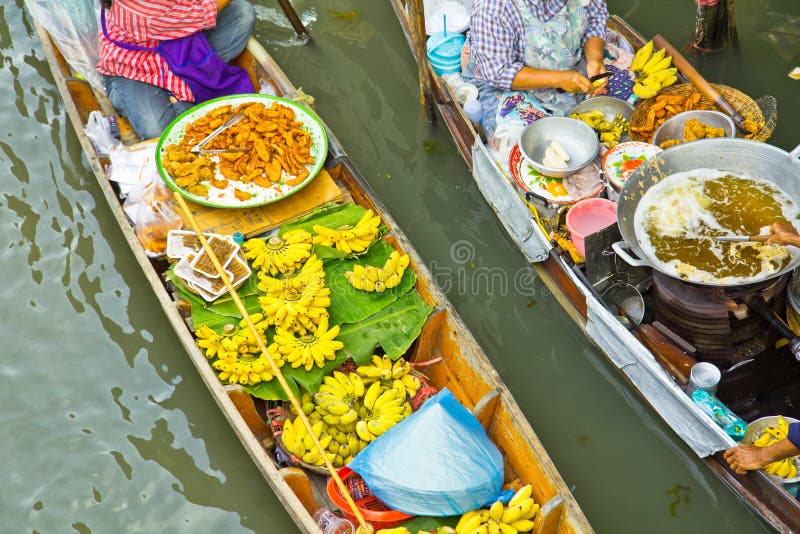 Selling food on a boat at floating market, Thailand