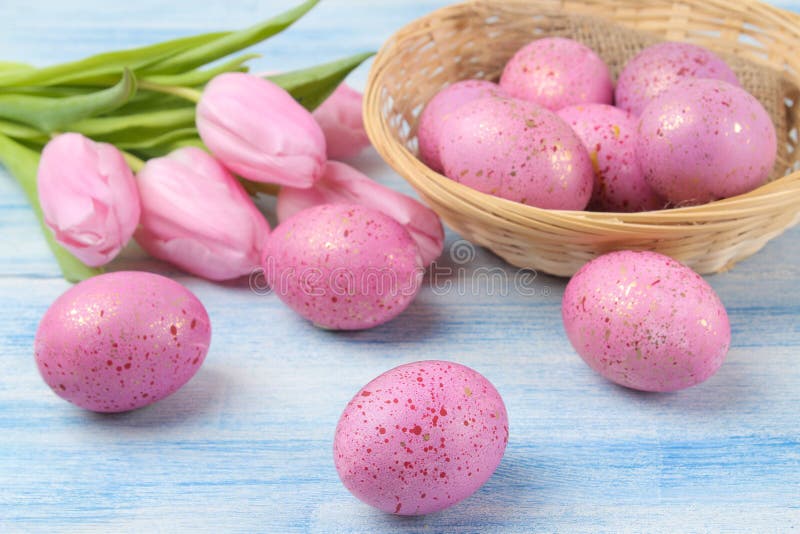 Semana Santa Huevos de Pascua rosados en una cesta y tulipanes de las flores en una tabla de madera azul Pascua feliz holidays fotografía de archivo libre de regalías Semana Santa Huevos de Pascua rosados en una cesta y tulipanes de las flores en una tabla de madera azul Pascua feliz holidays fotografía de archivo libre de regalías