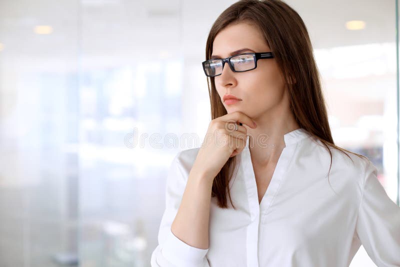 Sembler modernes de femme d'affaires concernés tout en se tenant dans le bureau photo stock Sembler modernes de femme d'affaires concernés tout en se tenant dans le bureau photo stock