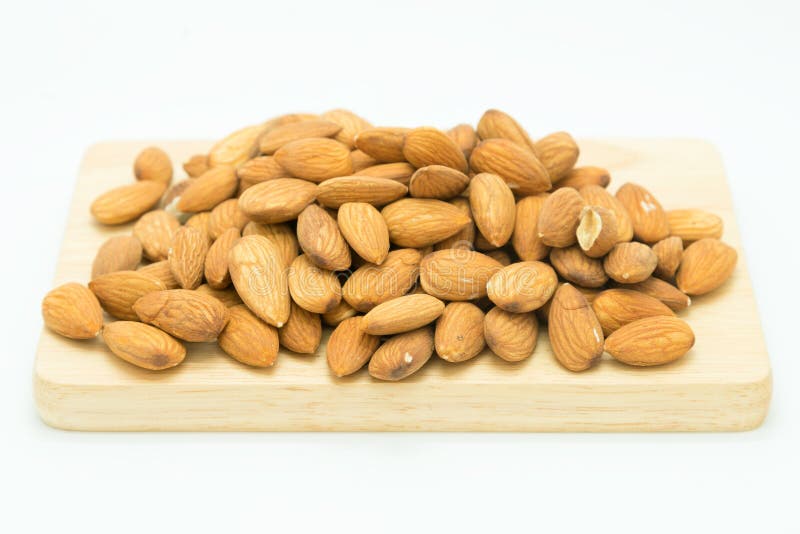Semente marrom fresca das amêndoas na placa de madeira fotos de stock royalty free