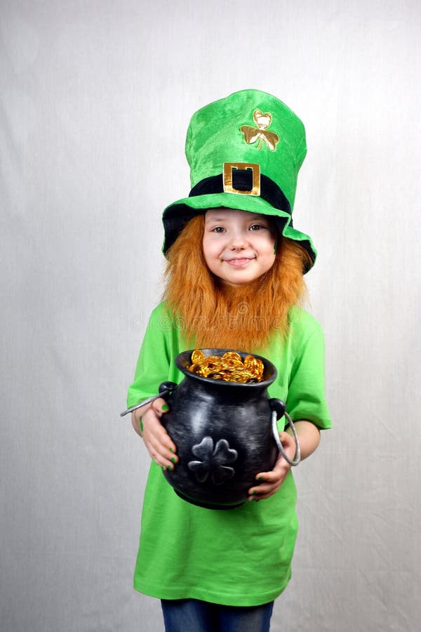 Semester på helgon-patrioter. Sväng liten flicka i gröna kläder med dekorativt rött skägg och leprechaun-hatt grön royaltyfria foton