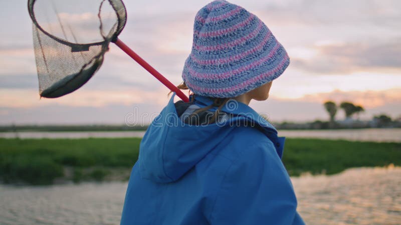 Semesterflicka vilande flodbank vid solnedläggning. flyga honfjäril lager videofilmer