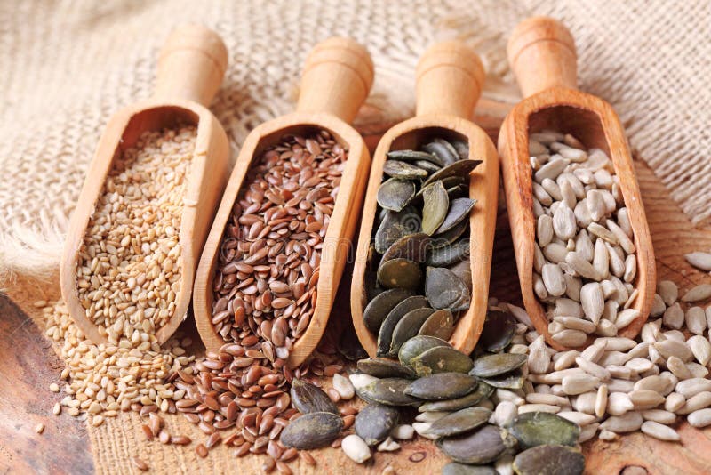 Sesame, flax, pumpkin and sunflower seeds in wooden spoons. Sesame, flax, pumpkin and sunflower seeds in wooden spoons