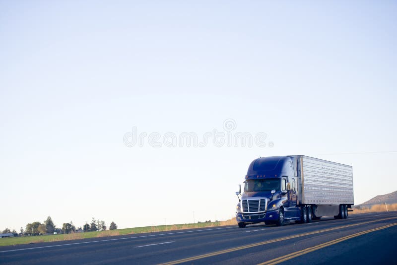 Semi o reboque moderno azul da japona do caminhão leva a carga na estrada