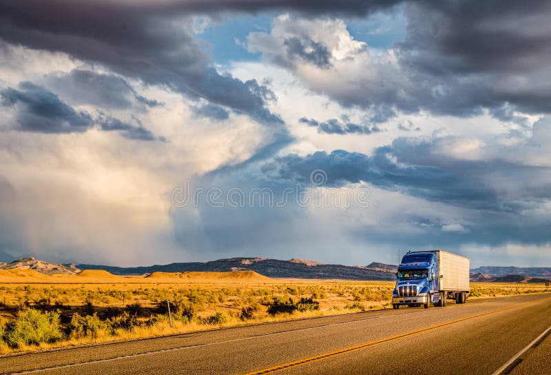 Hermoso de clásico productos semi-terminados remolque camión sobre el vacío carretera el cielo en dorado la luz sobre el atardecer.