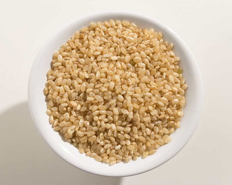 Semilla corta del arroz del grano del conjunto Vista superior de granos en un cuenco blanco imagen de archivo Semilla corta del arroz del grano del conjunto Vista superior de granos en un cuenco blanco imagen de archivo
