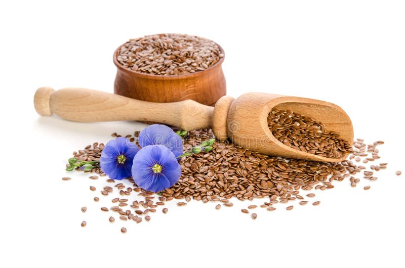 Semillas de lino en el cuenco de madera, la cucharada de madera y las flores de la belleza en el fondo blanco Phytotherapy