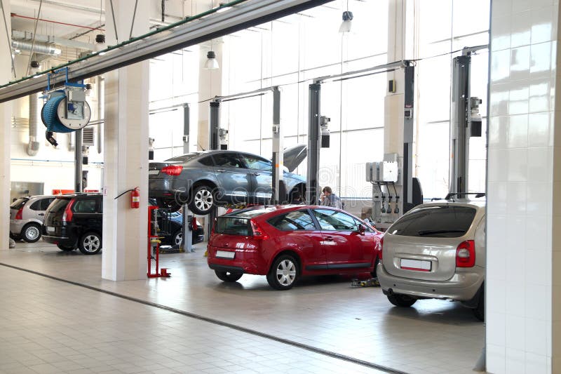 The image of car-care workshop and cars near the lifts. The image of car-care workshop and cars near the lifts