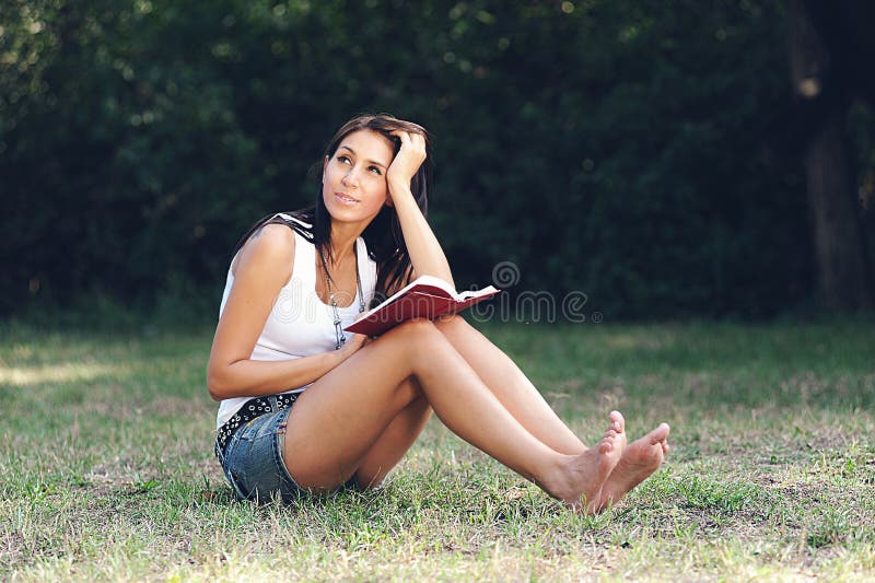 Girl in a park reading a book. Girl in a park reading a book.