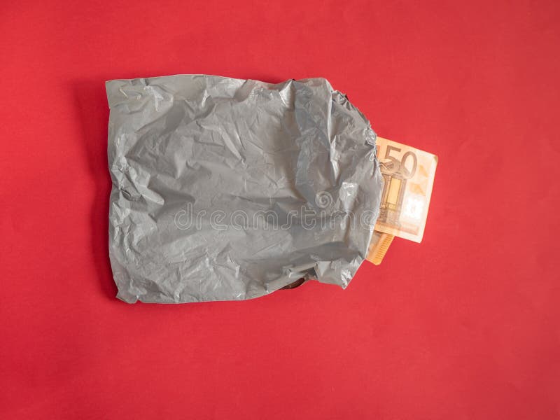 Grey plastic delivery bag with money on red background. Grey plastic delivery bag with money on red background