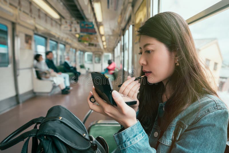 Senhora asiática bonita que põe sobre batons fotos de stock