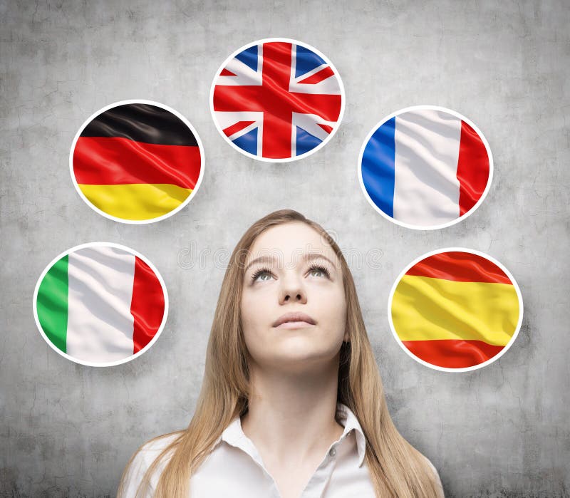 A senhora bonita é cercada por bolhas com as bandeiras de países europeus (italiano, alemão, Grâ Bretanha, francês, espanhóis) fotografia de stock A senhora bonita é cercada por bolhas com as bandeiras de países europeus (italiano, alemão, Grâ Bretanha, francês, espanhóis) fotografia de stock