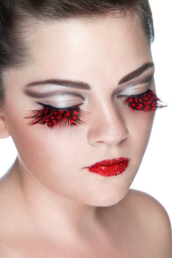 Young lady with false red eyelashes and red rhinestones on lips on white background. Young lady with false red eyelashes and red rhinestones on lips on white background