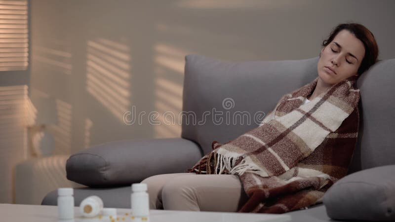Senhora deprimida nova que encontra-se no sof? ap?s ter tomado a demasiado comprimidos, tentativa do suic?dio foto de stock Senhora deprimida nova que encontra-se no sof? ap?s ter tomado a demasiado comprimidos, tentativa do suic?dio foto de stock