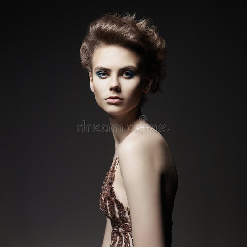 Studio photo of elegant lady with color smoky eyes makeup. Young woman with fashionable haircut. Studio photo of elegant lady with color smoky eyes makeup. Young woman with fashionable haircut