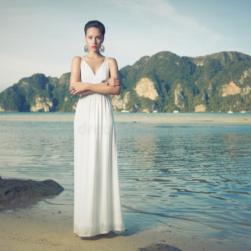 Portrait of beautiful lady in white dress on seashore. Portrait of beautiful lady in white dress on seashore