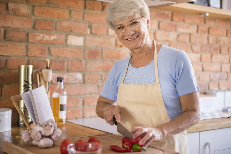Senhora superior na cozinha imagem de stock royalty free Senhora superior na cozinha imagem de stock royalty free