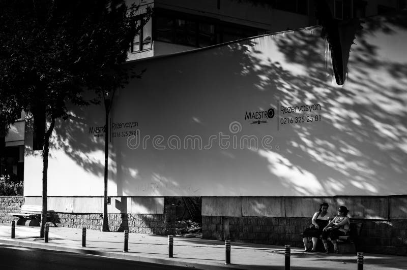 Senhoras idosas que descansam sob a placa de propaganda imagem de stock royalty free Senhoras idosas que descansam sob a placa de propaganda imagem de stock royalty free