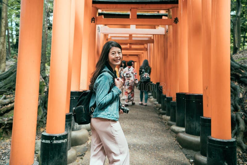 Senhoras japonesas no quimono que andam sob o torii imagem de stock