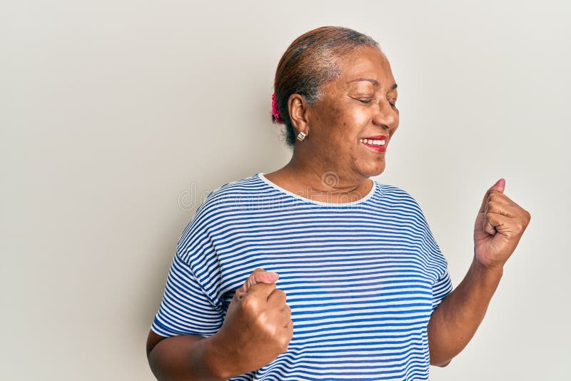Senior african american woman wearing casual clothes celebrating surprised and amazed for success with arms raised and eyes closed stock photos